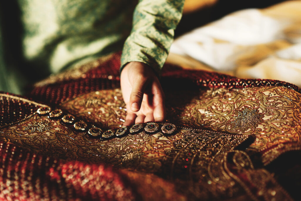 Groom in green shirt touches his red sherwani
